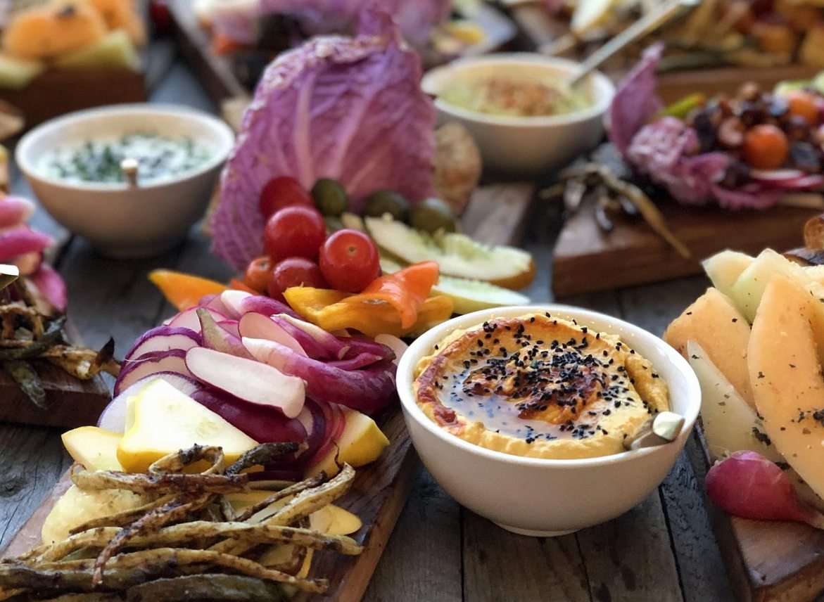 Bol colorido con verduras frescas y salsas en un café vegano